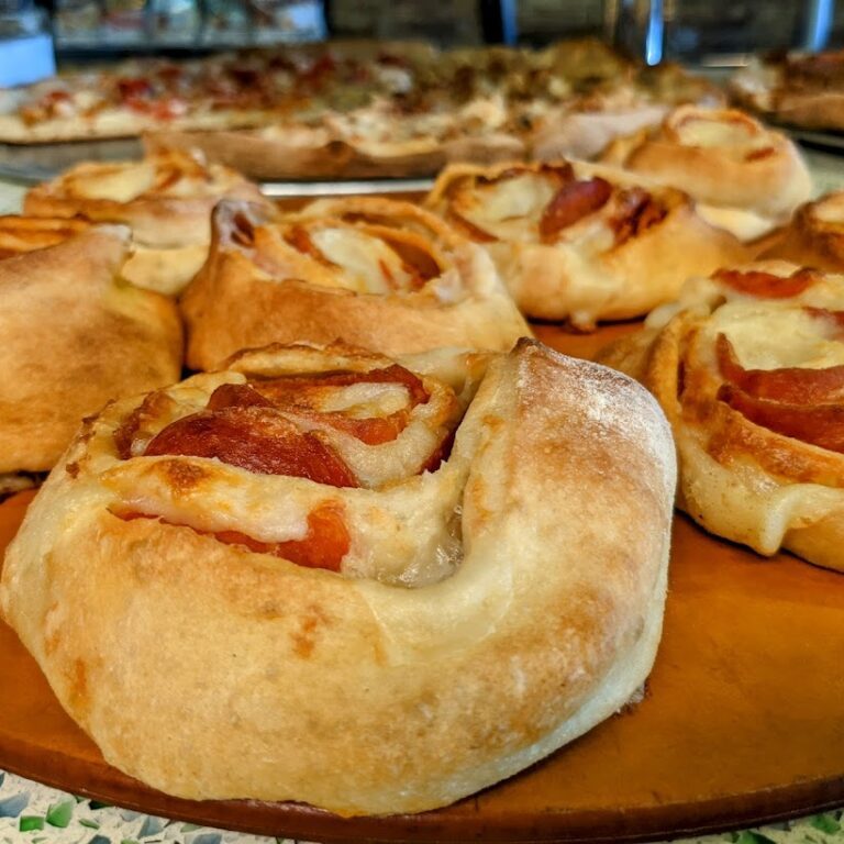 A plate of pizza rolls on a wooden table.